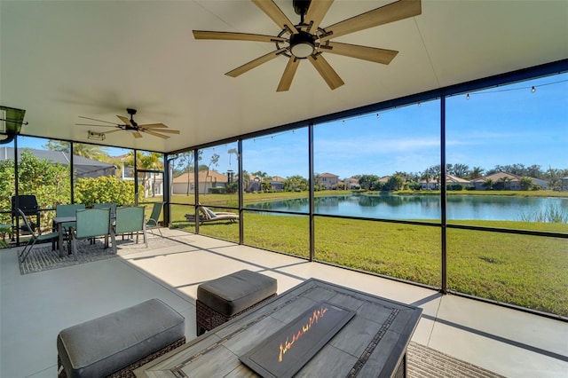 unfurnished sunroom with a water view and ceiling fan