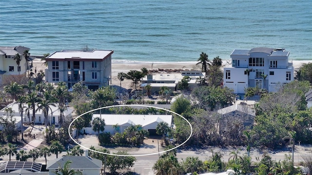 birds eye view of property featuring a water view and a beach view