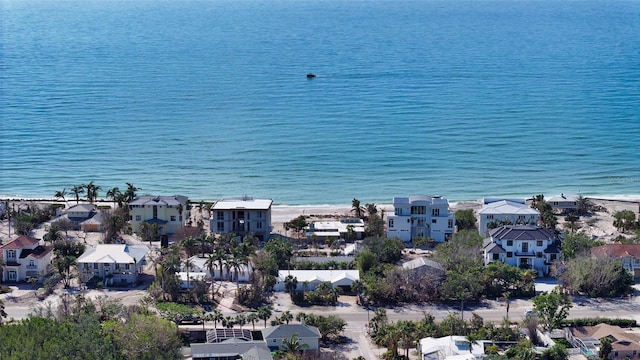 birds eye view of property with a water view and a beach view