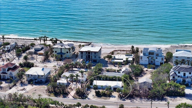 drone / aerial view with a water view and a beach view