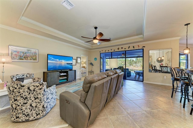 tiled living room featuring a raised ceiling, crown molding, and ceiling fan