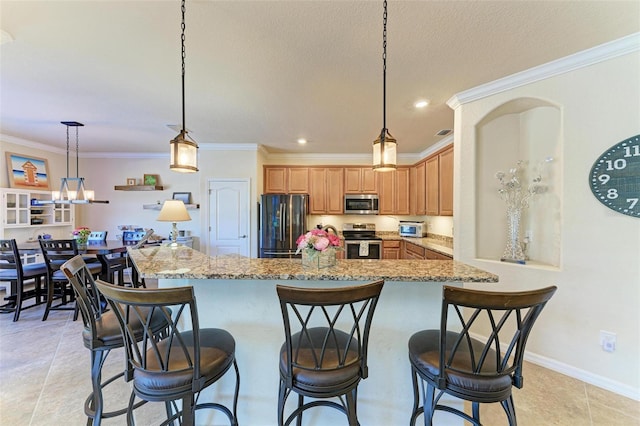 kitchen featuring a kitchen bar, hanging light fixtures, ornamental molding, kitchen peninsula, and stainless steel appliances