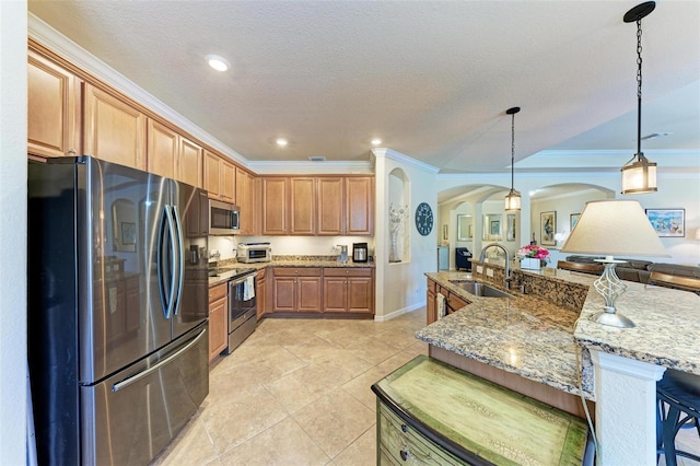 kitchen with sink, a breakfast bar area, ornamental molding, appliances with stainless steel finishes, and pendant lighting