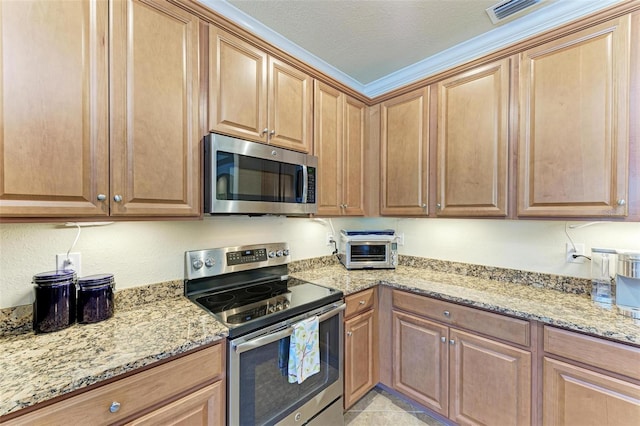 kitchen with light stone countertops, appliances with stainless steel finishes, and a textured ceiling