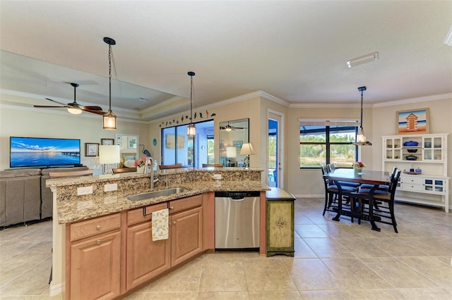 kitchen with decorative light fixtures, dishwasher, sink, light stone counters, and a center island with sink