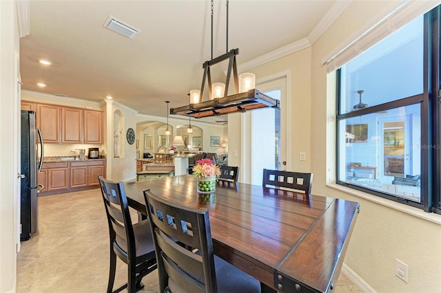 tiled dining room featuring ornamental molding