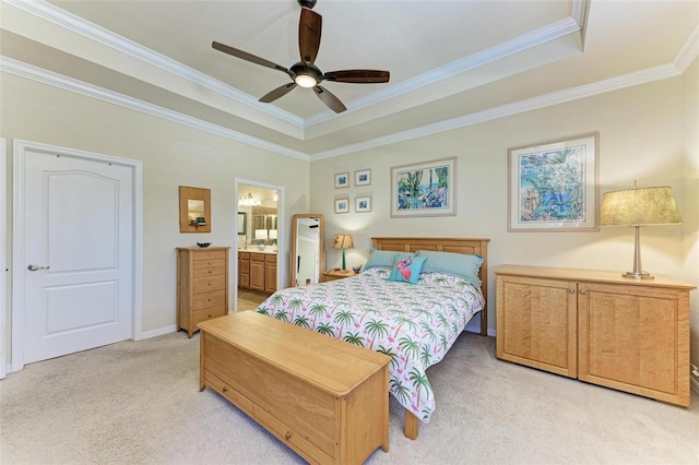 bedroom featuring crown molding, ensuite bath, ceiling fan, a tray ceiling, and light colored carpet