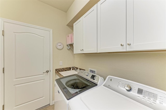 clothes washing area with cabinets, sink, and washer and dryer