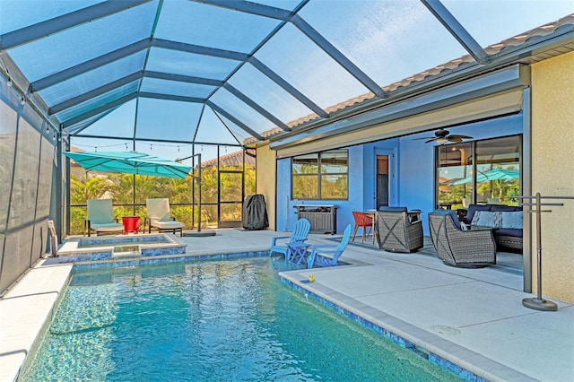 view of swimming pool featuring a patio area, an in ground hot tub, ceiling fan, and glass enclosure