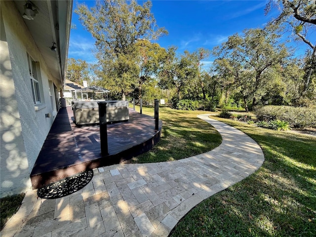 exterior space featuring a lawn and a hot tub