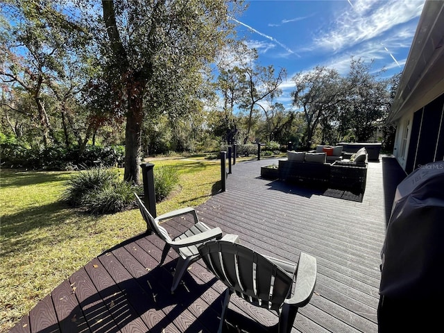 deck featuring an outdoor living space, area for grilling, and a lawn