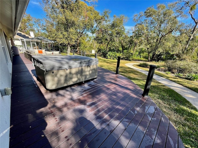 wooden terrace featuring a hot tub, a gazebo, and a lawn