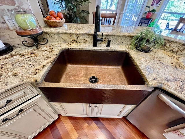 details featuring sink, hardwood / wood-style floors, and light stone countertops
