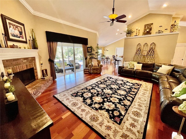 living room featuring lofted ceiling, hardwood / wood-style floors, ornamental molding, and a brick fireplace