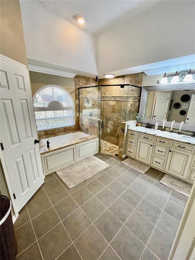 bathroom featuring plus walk in shower, tile patterned floors, vanity, and a textured ceiling