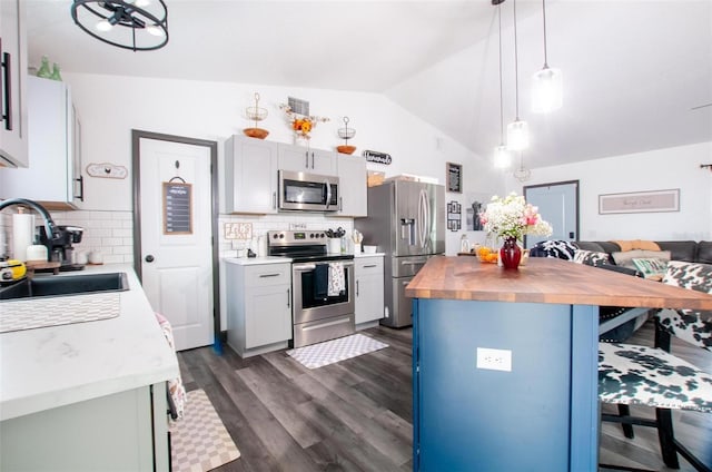 kitchen featuring tasteful backsplash, butcher block counters, appliances with stainless steel finishes, and sink