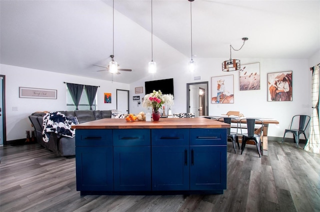 kitchen with lofted ceiling, dark wood-type flooring, blue cabinetry, and wooden counters