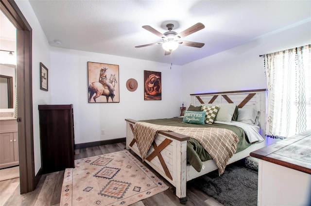 bedroom featuring ensuite bathroom, hardwood / wood-style floors, and ceiling fan