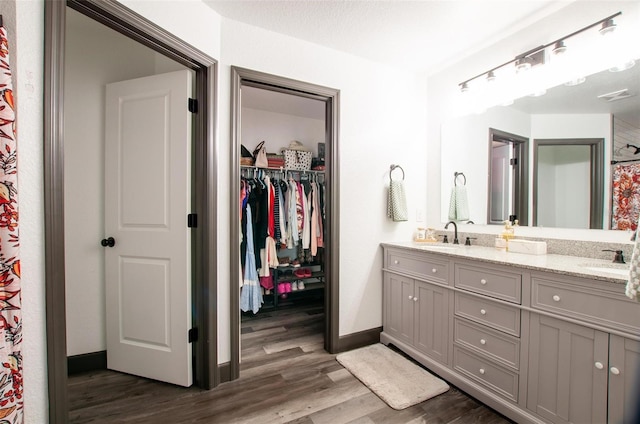 bathroom with wood-type flooring, vanity, and a textured ceiling