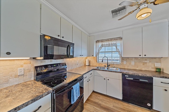 kitchen with sink, crown molding, black appliances, light hardwood / wood-style floors, and white cabinets