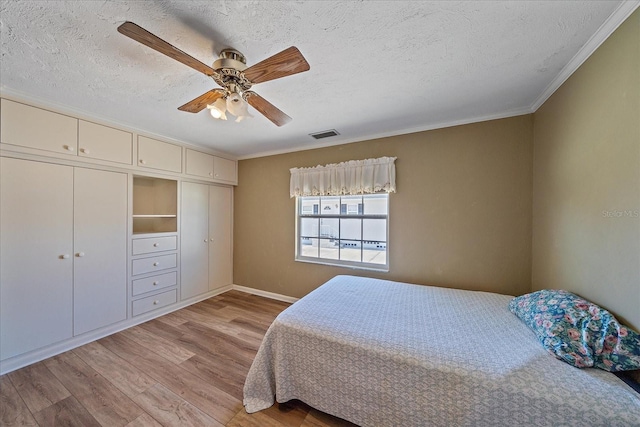 bedroom featuring ceiling fan, a textured ceiling, a closet, and light wood-type flooring