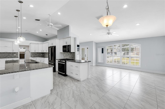 kitchen featuring white cabinetry, lofted ceiling, hanging light fixtures, and black appliances