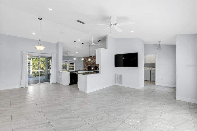 unfurnished living room with ceiling fan, high vaulted ceiling, separate washer and dryer, and sink