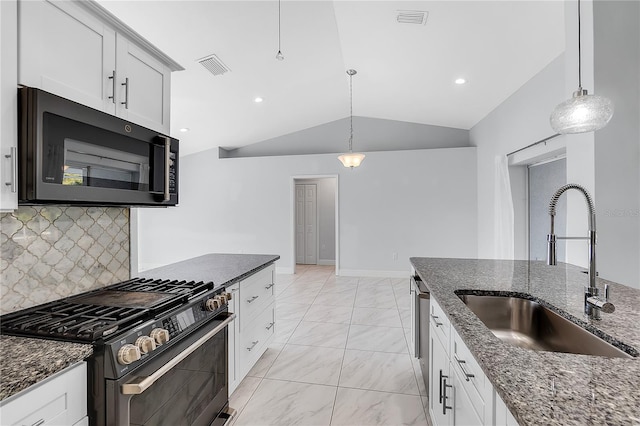 kitchen with lofted ceiling, sink, stainless steel gas range, and white cabinets