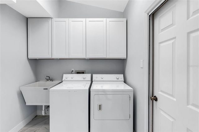 laundry room with cabinets, sink, and washer and clothes dryer