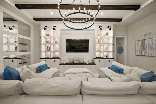 living room featuring beamed ceiling and built in shelves