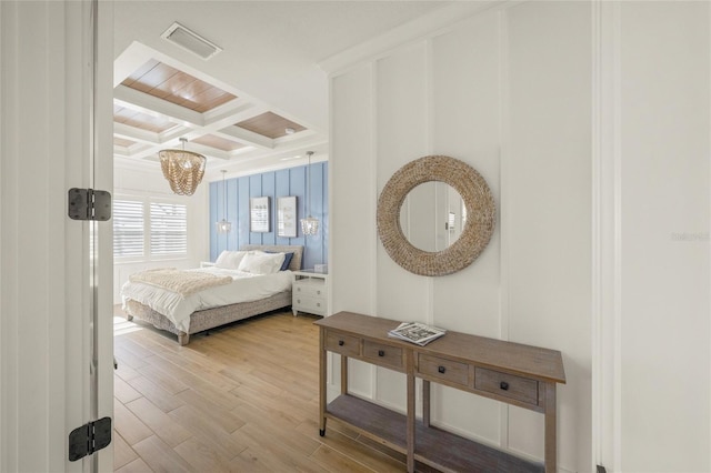 bedroom featuring beamed ceiling, coffered ceiling, and light wood-type flooring