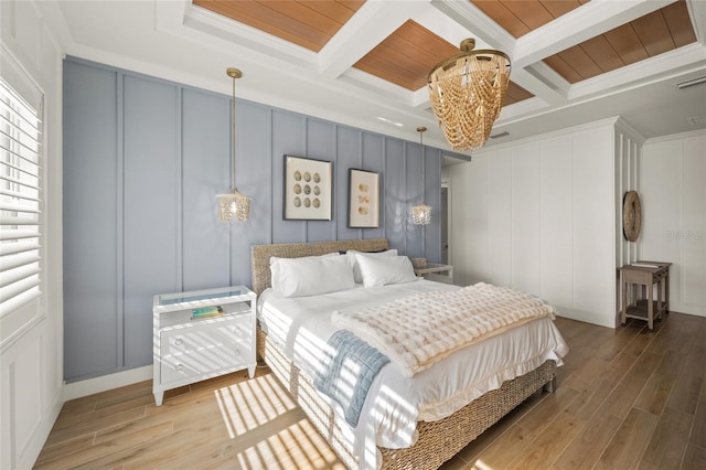 bedroom featuring beam ceiling, crown molding, coffered ceiling, and light hardwood / wood-style floors