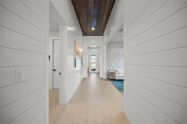 hall with wood ceiling and light hardwood / wood-style floors