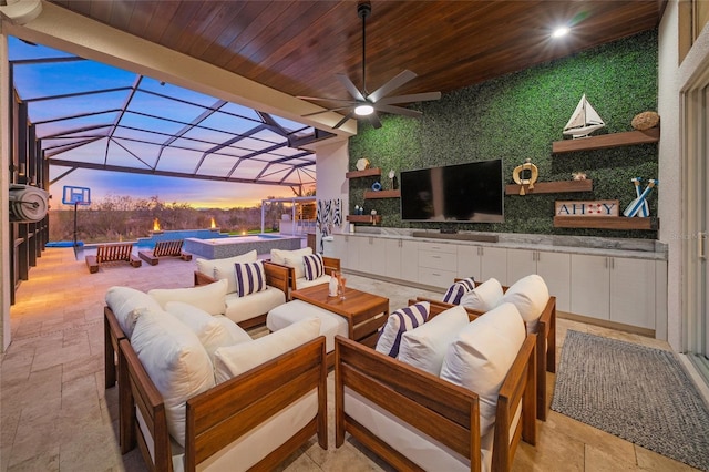 view of patio / terrace featuring a lanai, an outdoor hangout area, an outdoor hot tub, and ceiling fan