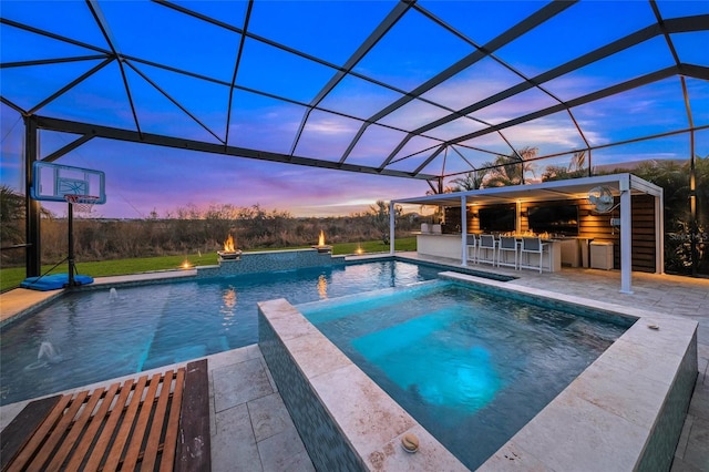 view of pool featuring glass enclosure, exterior bar, a patio area, area for grilling, and an in ground hot tub