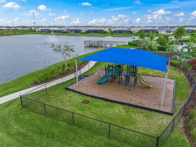 view of playground with a lawn and a water view