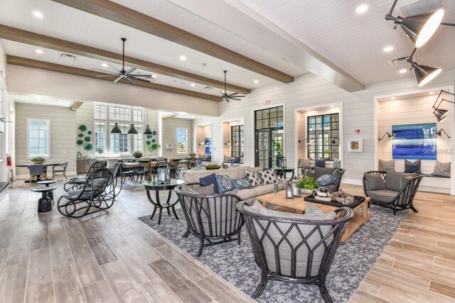 living room with plenty of natural light, beamed ceiling, and ceiling fan