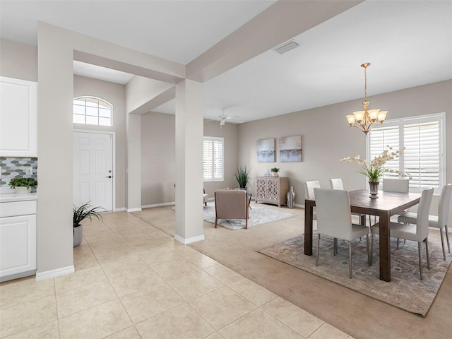 tiled dining room featuring plenty of natural light and ceiling fan with notable chandelier