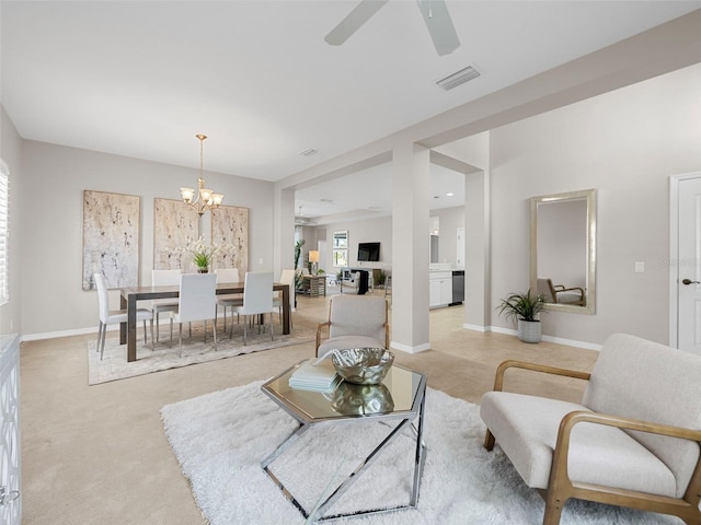 carpeted living room featuring ceiling fan with notable chandelier