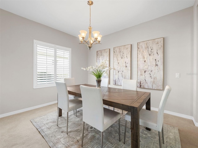 carpeted dining room featuring a chandelier