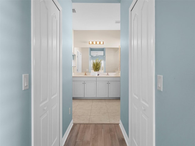 hall with sink and light wood-type flooring