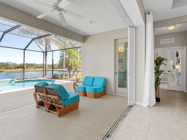 view of patio featuring ceiling fan, a water view, and glass enclosure