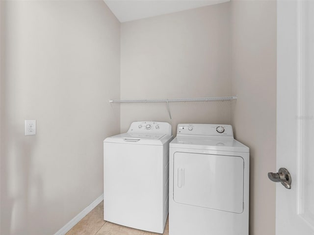 washroom with washing machine and dryer and light tile patterned flooring