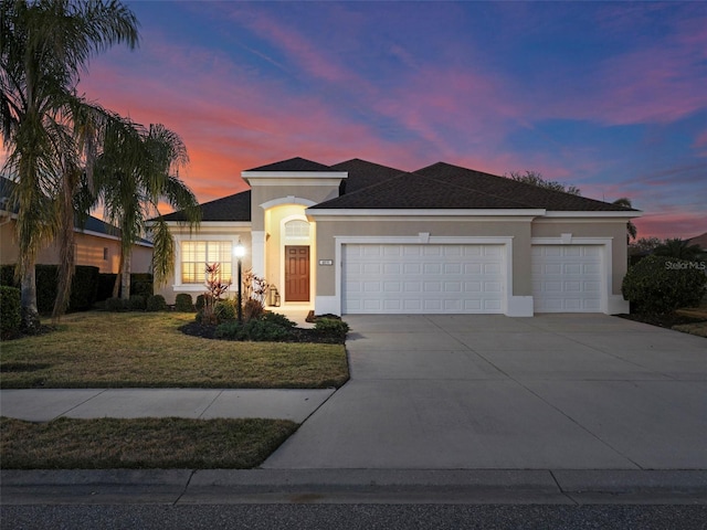 view of front of house with a garage and a yard