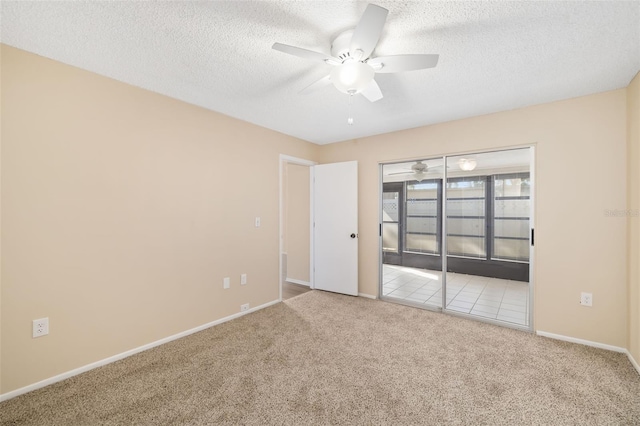 carpeted empty room featuring ceiling fan and a textured ceiling