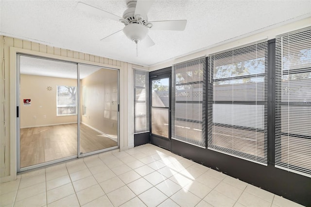 unfurnished sunroom with plenty of natural light and ceiling fan