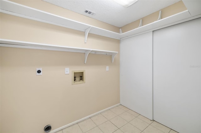 washroom featuring tile patterned floors, washer hookup, a textured ceiling, and electric dryer hookup