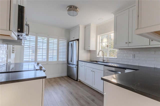 kitchen featuring plenty of natural light, stainless steel appliances, sink, and white cabinets