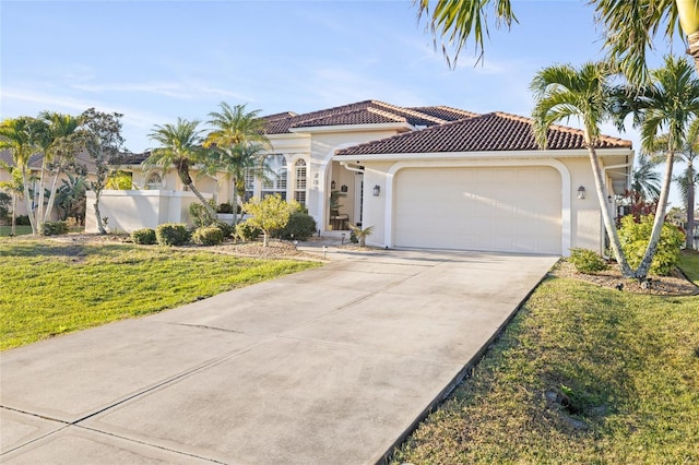 mediterranean / spanish house with a garage and a front lawn