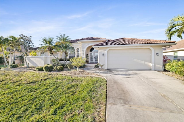 mediterranean / spanish home with a garage, a front yard, and french doors